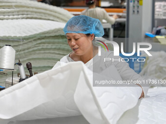 A worker makes bedding at a workshop of Wadfeng Automotive Supplies (Nantong) Co., Ltd. in Duntou town, Haian city, East China's Jiangsu pro...