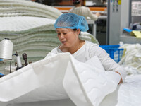 A worker makes bedding at a workshop of Wadfeng Automotive Supplies (Nantong) Co., Ltd. in Duntou town, Haian city, East China's Jiangsu pro...