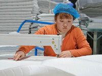 A worker makes bedding at a workshop of Wadfeng Automotive Supplies (Nantong) Co., Ltd. in Duntou town, Haian city, East China's Jiangsu pro...