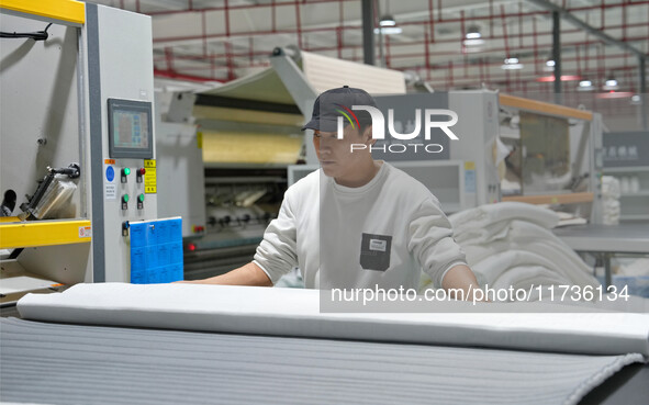 A worker makes bedding at a workshop of Wadfeng Automotive Supplies (Nantong) Co., Ltd. in Duntou town, Haian city, East China's Jiangsu pro...