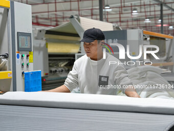 A worker makes bedding at a workshop of Wadfeng Automotive Supplies (Nantong) Co., Ltd. in Duntou town, Haian city, East China's Jiangsu pro...