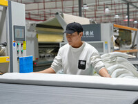 A worker makes bedding at a workshop of Wadfeng Automotive Supplies (Nantong) Co., Ltd. in Duntou town, Haian city, East China's Jiangsu pro...