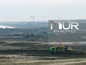 Workers operate large equipment at the construction site of the second phase of the Huaihe River Inlet Waterway project in Qingjiangpu distr...