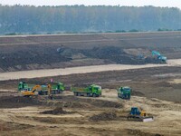 Workers operate large equipment at the construction site of the second phase of the Huaihe River Inlet Waterway project in Qingjiangpu distr...