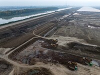 Workers operate large equipment at the construction site of the second phase of the Huaihe River Inlet Waterway project in Qingjiangpu distr...