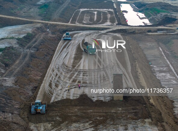 Workers operate large equipment at the construction site of the second phase of the Huaihe River Inlet Waterway project in Qingjiangpu distr...