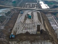 Workers operate large equipment at the construction site of the second phase of the Huaihe River Inlet Waterway project in Qingjiangpu distr...