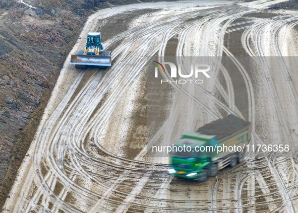 Workers operate large equipment at the construction site of the second phase of the Huaihe River Inlet Waterway project in Qingjiangpu distr...