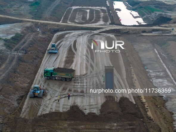 Workers operate large equipment at the construction site of the second phase of the Huaihe River Inlet Waterway project in Qingjiangpu distr...