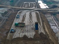 Workers operate large equipment at the construction site of the second phase of the Huaihe River Inlet Waterway project in Qingjiangpu distr...