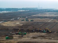 Workers operate large equipment at the construction site of the second phase of the Huaihe River Inlet Waterway project in Qingjiangpu distr...