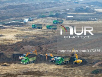 Workers operate large equipment at the construction site of the second phase of the Huaihe River Inlet Waterway project in Qingjiangpu distr...