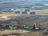 Workers operate large equipment at the construction site of the second phase of the Huaihe River Inlet Waterway project in Qingjiangpu distr...