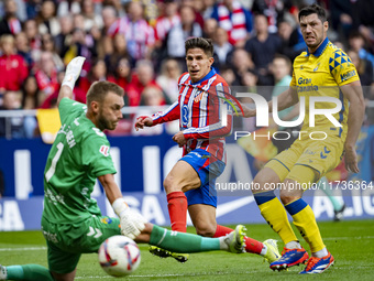 Giuliano Simeone of Atletico de Madrid (C) attempts a kick to score a goal between Jacobus Cillessen of UD Las Palmas (L) and Scott McKenna...