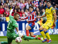 Giuliano Simeone of Atletico de Madrid (C) attempts a kick to score a goal between Jacobus Cillessen of UD Las Palmas (L) and Scott McKenna...