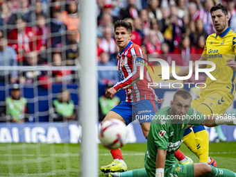 Giuliano Simeone of Atletico de Madrid (L) attempts a kick to score a goal against Jacobus Cillessen of UD Las Palmas (C) and Scott McKenna...