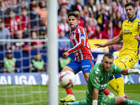 Giuliano Simeone of Atletico de Madrid (L) attempts a kick to score a goal against Jacobus Cillessen of UD Las Palmas (C) and Scott McKenna...