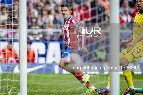 Giuliano Simeone of Atletico de Madrid shows the ball of his goal during the La Liga EA Sports 2024/25 football match between Atletico de Ma...