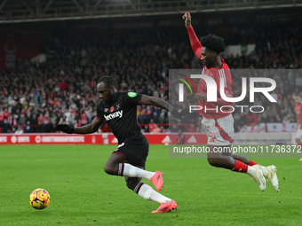 Ola Aina of Nottingham Forest puts pressure on Michail Antonio of West Ham United during the Premier League match between Nottingham Forest...