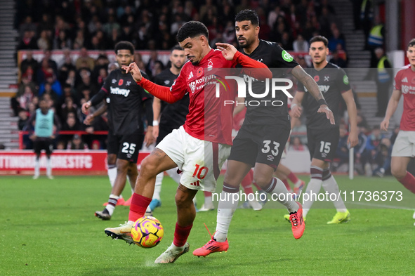 Morgan Gibbs-White of Nottingham Forest competes with Emerson Palmieri of West Ham United during the Premier League match between Nottingham...