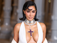 Kim Kardashian wearing a custom Gucci dress and coat with a Tallarico pearl choker, Bvlgari pearl and diamond necklace, and Princess Diana's...