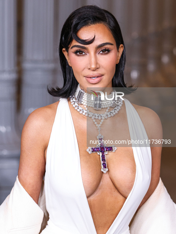 Kim Kardashian wearing a custom Gucci dress and coat with a Tallarico pearl choker, Bvlgari pearl and diamond necklace, and Princess Diana's...