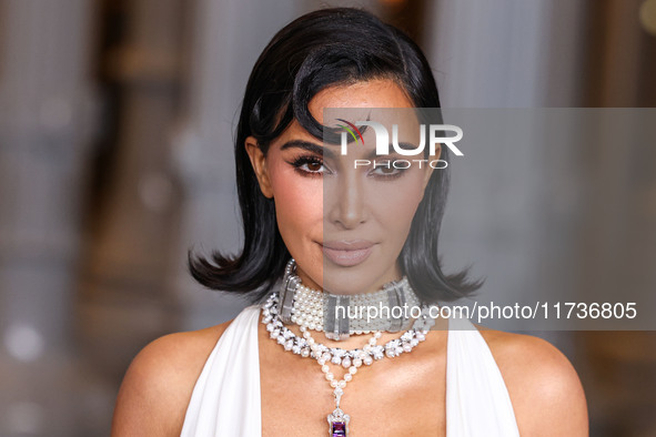 Kim Kardashian wearing a custom Gucci dress and coat with a Tallarico pearl choker, Bvlgari pearl and diamond necklace, and Princess Diana's...