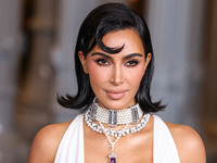 Kim Kardashian wearing a custom Gucci dress and coat with a Tallarico pearl choker, Bvlgari pearl and diamond necklace, and Princess Diana's...