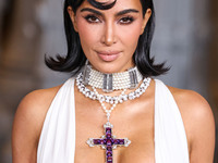 Kim Kardashian wearing a custom Gucci dress and coat with a Tallarico pearl choker, Bvlgari pearl and diamond necklace, and Princess Diana's...