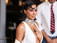 Kim Kardashian wearing a custom Gucci dress and coat with a Tallarico pearl choker, Bvlgari pearl and diamond necklace, and Princess Diana's...