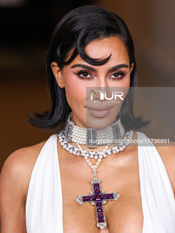 Kim Kardashian wearing a custom Gucci dress and coat with a Tallarico pearl choker, Bvlgari pearl and diamond necklace, and Princess Diana's...