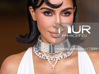 Kim Kardashian wearing a custom Gucci dress and coat with a Tallarico pearl choker, Bvlgari pearl and diamond necklace, and Princess Diana's...