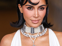 Kim Kardashian wearing a custom Gucci dress and coat with a Tallarico pearl choker, Bvlgari pearl and diamond necklace, and Princess Diana's...