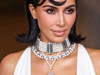 Kim Kardashian wearing a custom Gucci dress and coat with a Tallarico pearl choker, Bvlgari pearl and diamond necklace, and Princess Diana's...