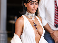 Kim Kardashian wearing a custom Gucci dress and coat with a Tallarico pearl choker, Bvlgari pearl and diamond necklace, and Princess Diana's...