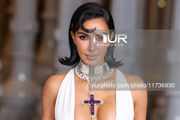 Kim Kardashian wearing a custom Gucci dress and coat with a Tallarico pearl choker, Bvlgari pearl and diamond necklace, and Princess Diana's...