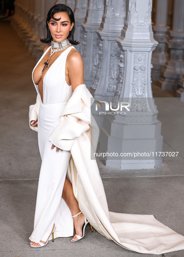 Kim Kardashian wearing a custom Gucci dress and coat with a Tallarico pearl choker, Bvlgari pearl and diamond necklace, and Princess Diana's...