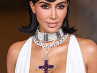 Kim Kardashian wearing a custom Gucci dress and coat with a Tallarico pearl choker, Bvlgari pearl and diamond necklace, and Princess Diana's...