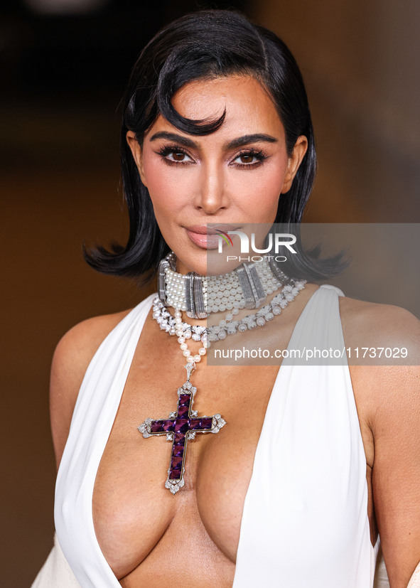 Kim Kardashian wearing a custom Gucci dress and coat with a Tallarico pearl choker, Bvlgari pearl and diamond necklace, and Princess Diana's...