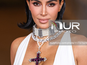 Kim Kardashian wearing a custom Gucci dress and coat with a Tallarico pearl choker, Bvlgari pearl and diamond necklace, and Princess Diana's...