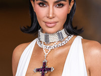 Kim Kardashian wearing a custom Gucci dress and coat with a Tallarico pearl choker, Bvlgari pearl and diamond necklace, and Princess Diana's...