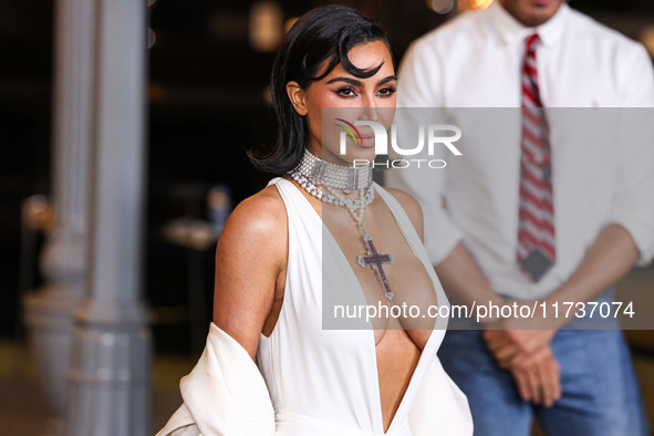 Kim Kardashian wearing a custom Gucci dress and coat with a Tallarico pearl choker, Bvlgari pearl and diamond necklace, and Princess Diana's...