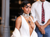 Kim Kardashian wearing a custom Gucci dress and coat with a Tallarico pearl choker, Bvlgari pearl and diamond necklace, and Princess Diana's...