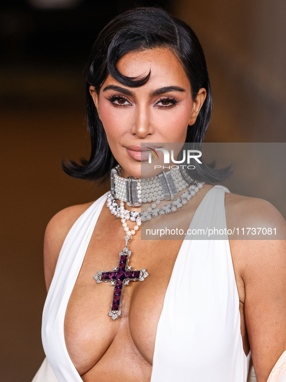 Kim Kardashian wearing a custom Gucci dress and coat with a Tallarico pearl choker, Bvlgari pearl and diamond necklace, and Princess Diana's...