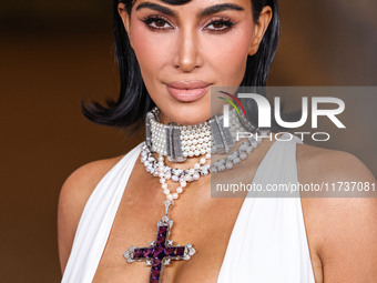 Kim Kardashian wearing a custom Gucci dress and coat with a Tallarico pearl choker, Bvlgari pearl and diamond necklace, and Princess Diana's...