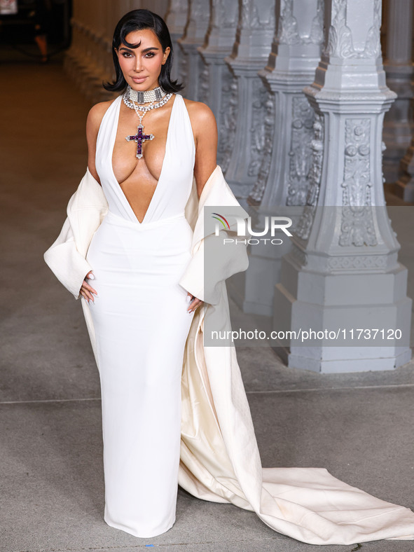 Kim Kardashian wearing a custom Gucci dress and coat with a Tallarico pearl choker, Bvlgari pearl and diamond necklace, and Princess Diana's...