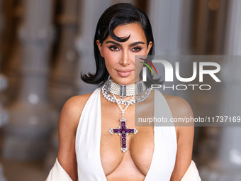 Kim Kardashian wearing a custom Gucci dress and coat with a Tallarico pearl choker, Bvlgari pearl and diamond necklace, and Princess Diana's...