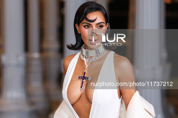 Kim Kardashian wearing a custom Gucci dress and coat with a Tallarico pearl choker, Bvlgari pearl and diamond necklace, and Princess Diana's...