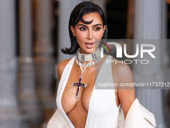 Kim Kardashian wearing a custom Gucci dress and coat with a Tallarico pearl choker, Bvlgari pearl and diamond necklace, and Princess Diana's...