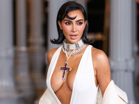 Kim Kardashian wearing a custom Gucci dress and coat with a Tallarico pearl choker, Bvlgari pearl and diamond necklace, and Princess Diana's...